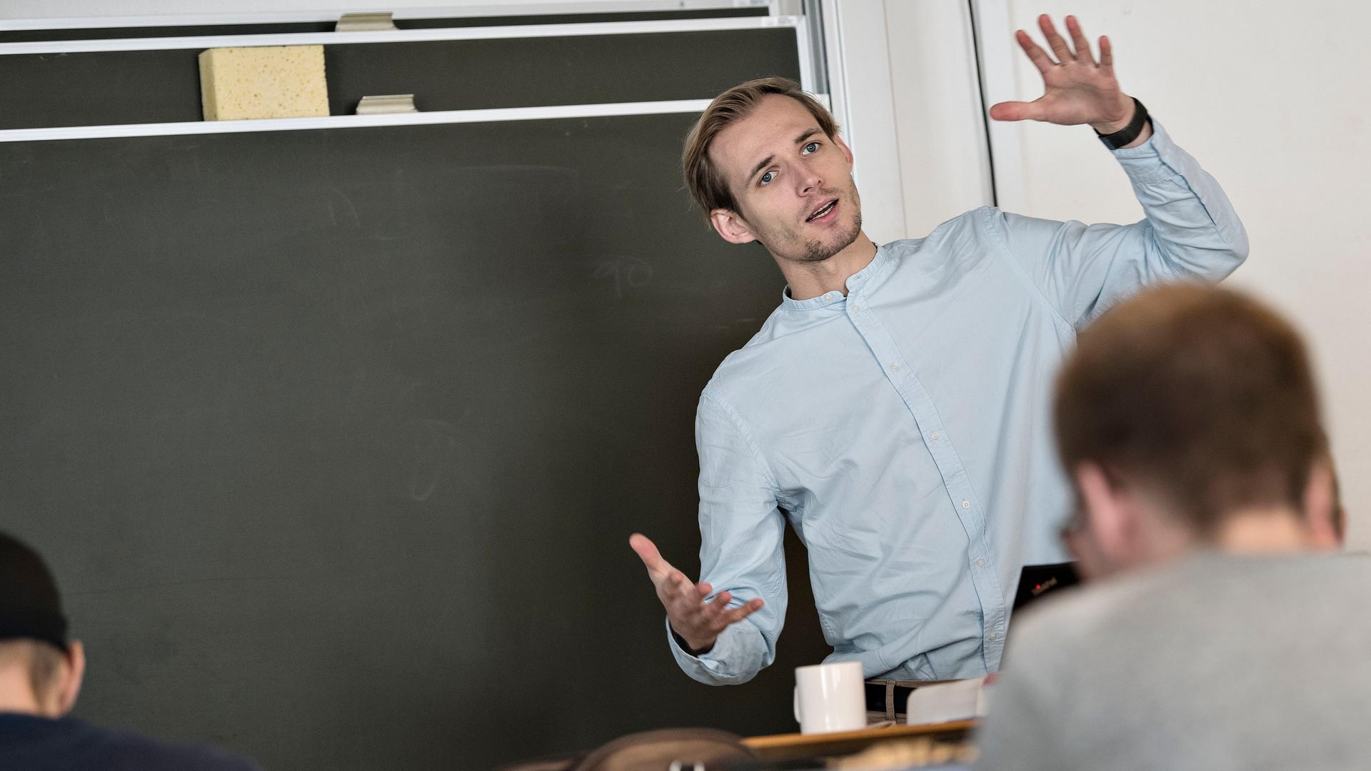 Underviser står ved tavle